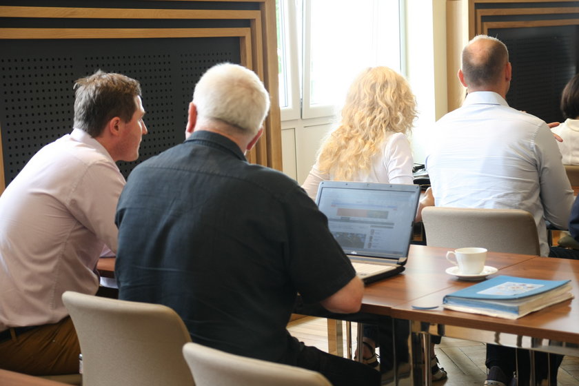Radni miasta Gdańska przeglądają internet na laptopie w trakcie sesji