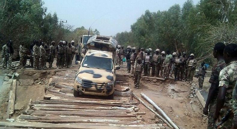 Nigerian troops are pictured in 2015 crossing a reconstructed bridge, previously destroyed by militants, in the northeastern town of Damasak 