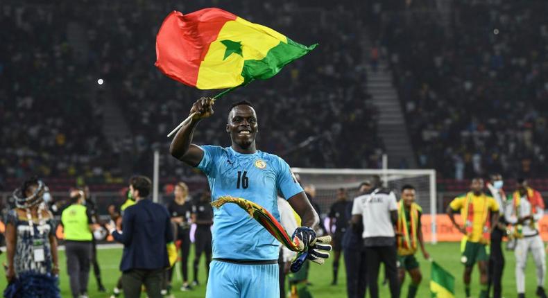 Edouard Mendy waves a Senegalese flag as he celebrates winning the Cup of Nations in Yaounde