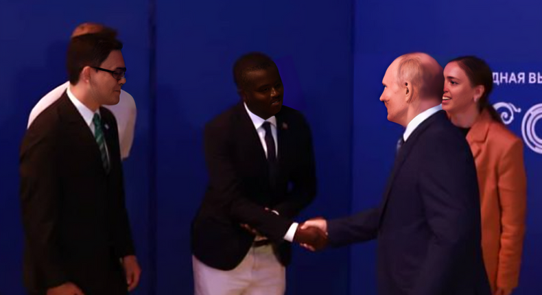 Davis Akampulira shakes hands with Russian President Vladimir Putin