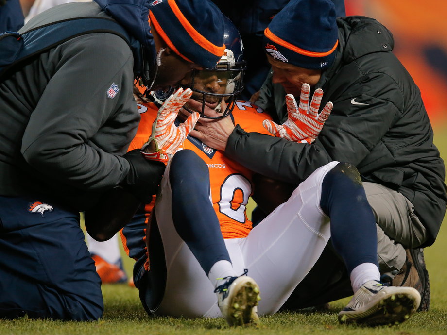Strong safety David Bruton of the Denver Broncos is attended to by trainers after a play that would force him out of the game with a reported concussion.