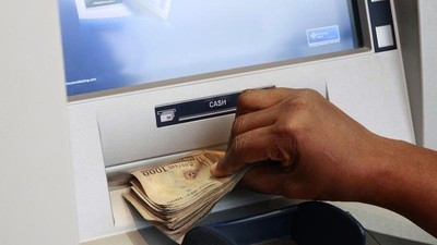 A woman takes Nigerian Naira from a bank's automated teller machine (ATM) in Ikeja district in the commercial capital Lagos November 12, 2014. 