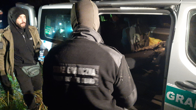 Syryjski migrant wchodzi do samochodu Straży Granicznej pod Narewką