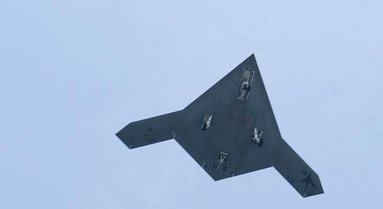 An X-47B pilot-less drone combat aircraft flies over the deck of the USS George H.W. Bush aircraft carrier in the Atlantic Ocean off the coast of Norfolk, Virginia, July 10, 2013. REUTERS/Rich-Joseph Facun