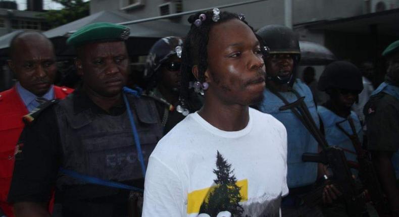 Naira Marley being led to court by men of the EFCC amidst a watertight security. [Twitter/@officialEFCC]