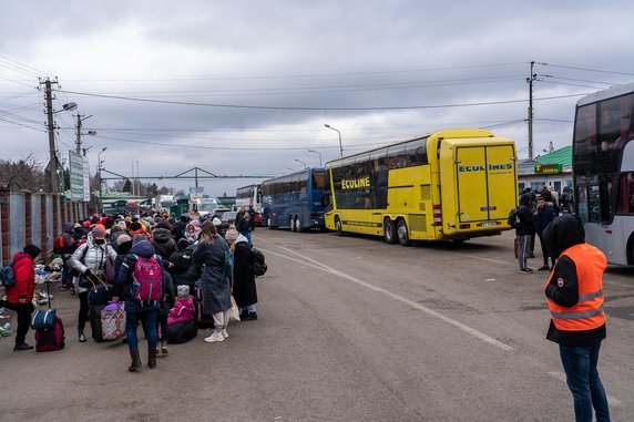 Kobiety z dziećmi czekające w kolejce na odprawę