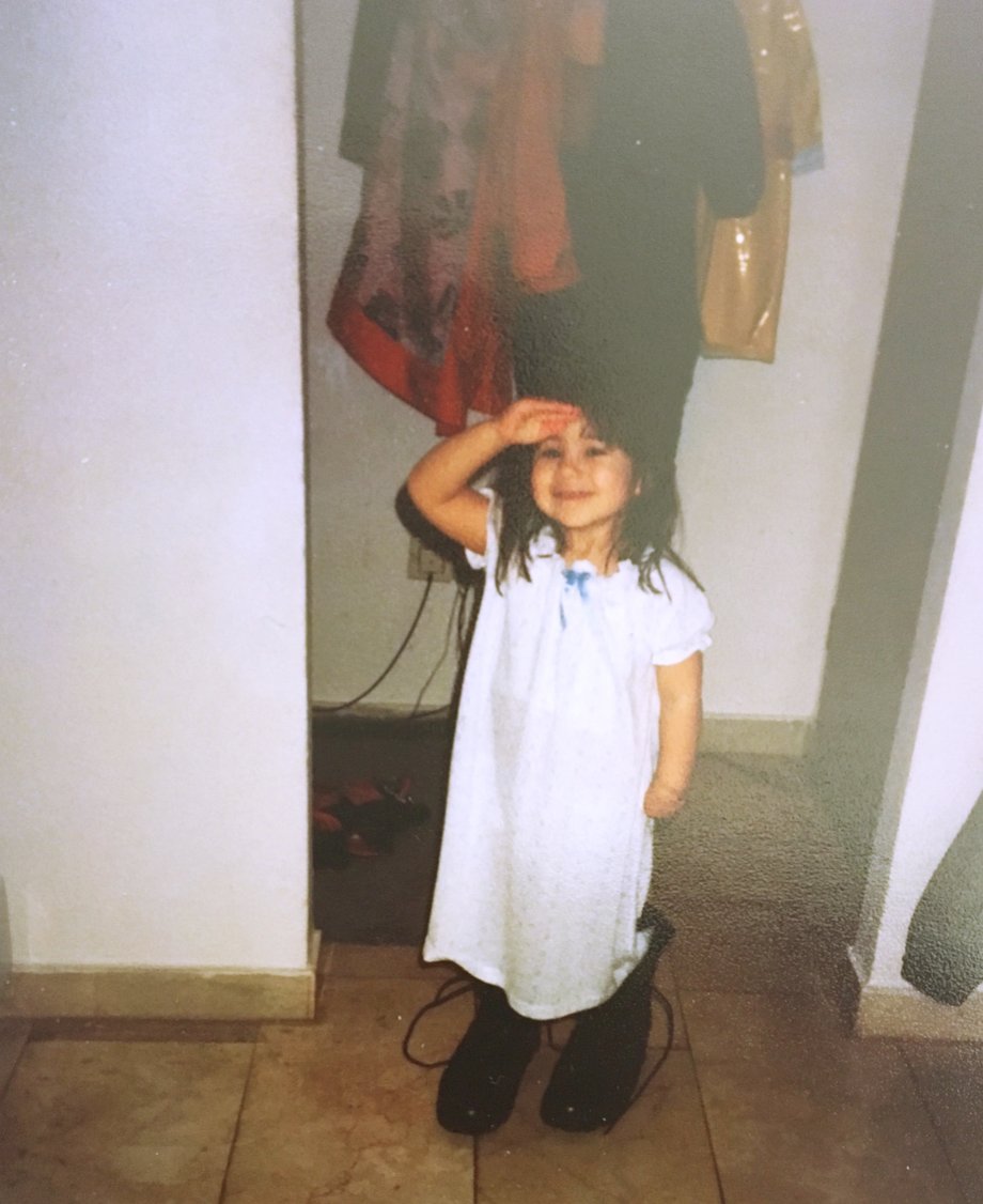 Wearing my dad's combat boots and saluting in our home in Ruppertsweiler, Germany in 1992.