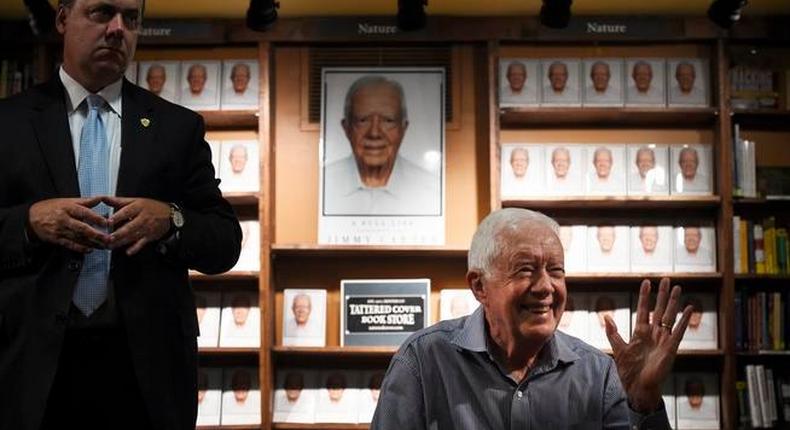 Former President Jimmy Carter waves to the crowd as he signs his new book titled A Full Life: Reflections at 90. 