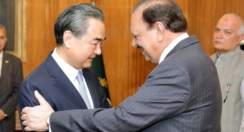 Pakistani President Mamnoon Hussain (R) shakes hands with Chinese Foreign Minister Wang Yi upon his arrival in Islamabad