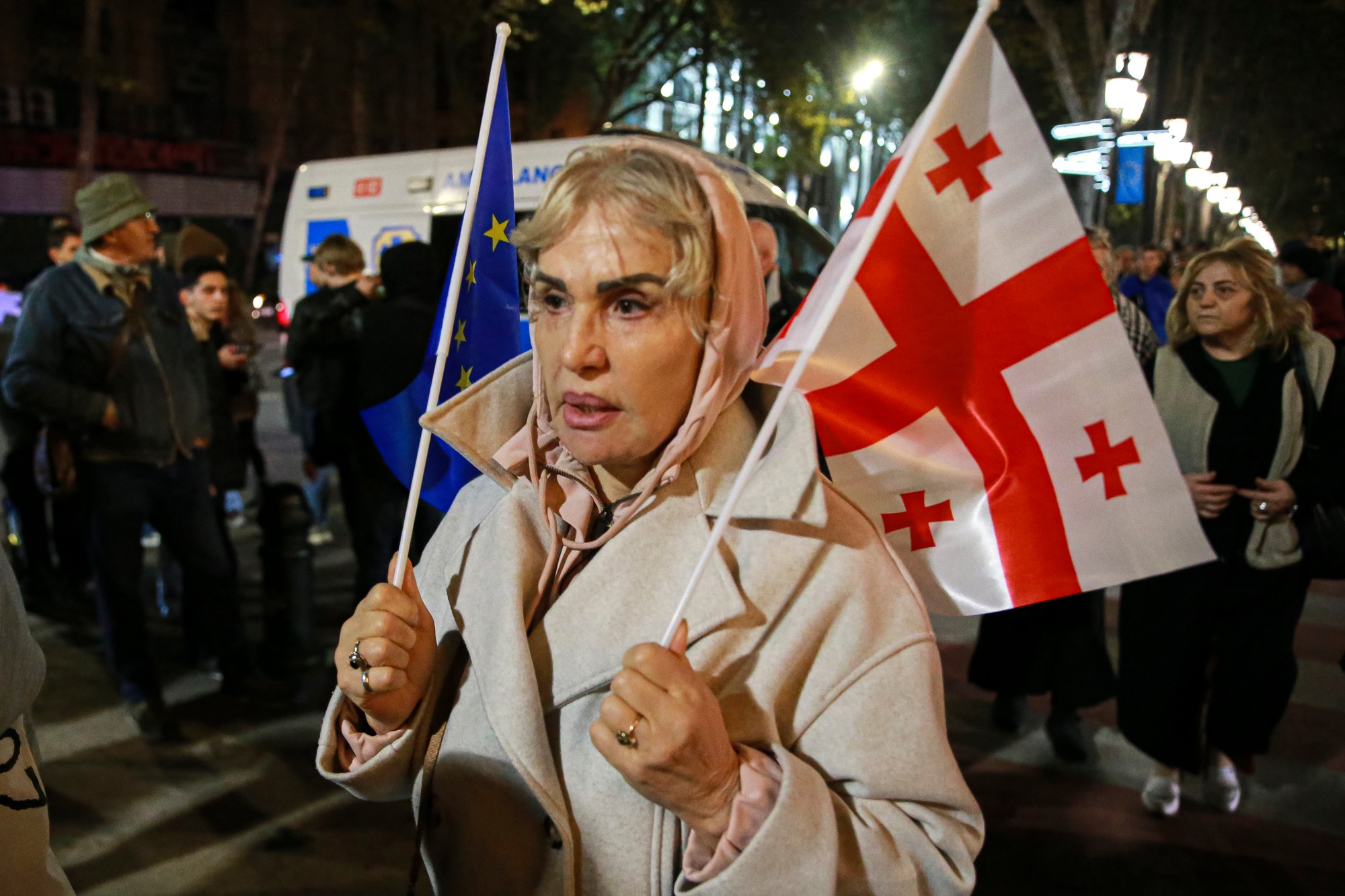 Demonštrantka drží vlajky EÚ a Ukrajiny počas opozičného protestu proti výsledkom parlamentných volieb v gruzínskom Tbilisi.