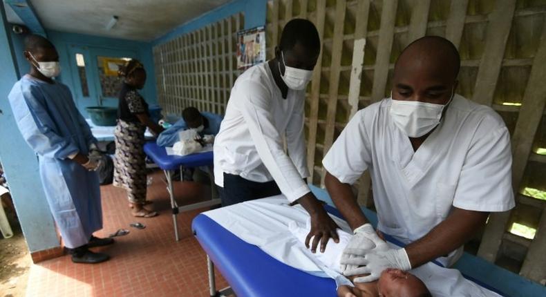 Medical staff use massage to treat a child with breathing problems in Abidjan