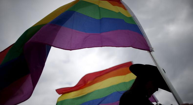 A woman holds rainbow flags for the grand entry at the International Gay Rodeo Association's Rodeo In the Rock in Little Rock, Arkansas, United States April 26, 2015. REUTERS/Lucy Nicholson