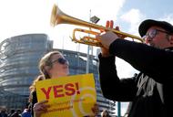 Demonstrators take part in a protest in front of the European Parliament as MEPs debate on modificat