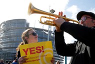 Demonstrators take part in a protest in front of the European Parliament as MEPs debate on modificat