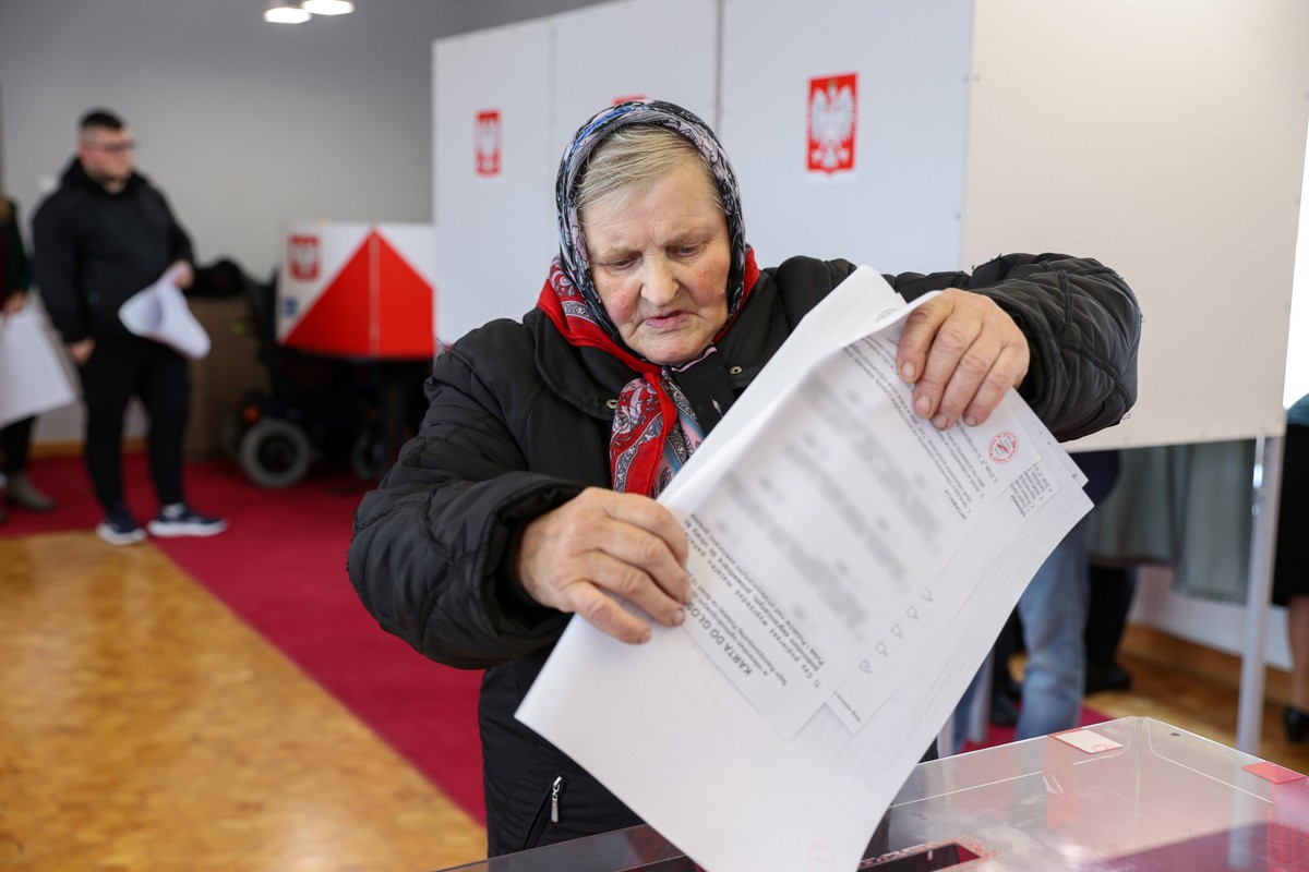 Głuchów, 15.10.2023. Wybory parlamentarne 2023. Kobieta w tradycyjnej łowickiej chuście głosuje w lokalu wyborczym w Głuchowie koło Rawy Mazowieckiej