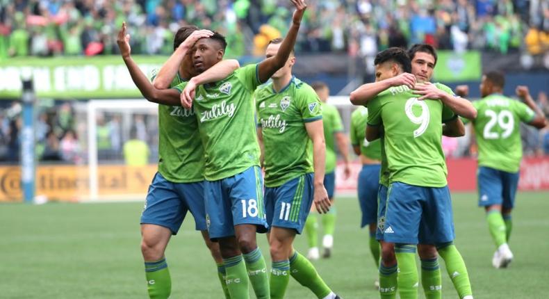 Seattle's Kelvin Leerdam, with arms raised, celebrates with teammates after putting the Sounders ahead on their way to a 3-1 victory over Toronto FC in the MLS Cup final on Sunday