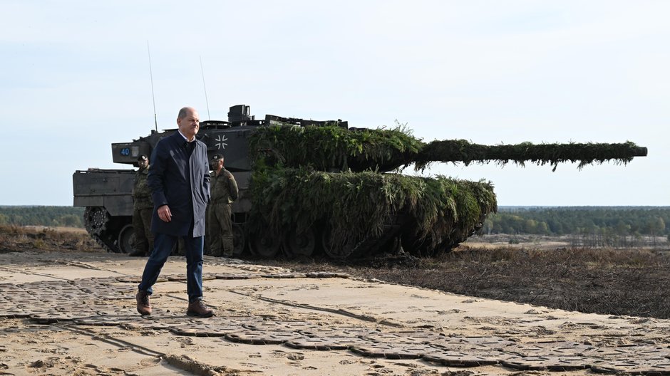 Kanclerz Niemiec Olaf Scholz na tle czołgu Leopard 2