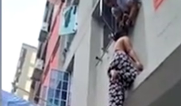 žena visi kroz prozor