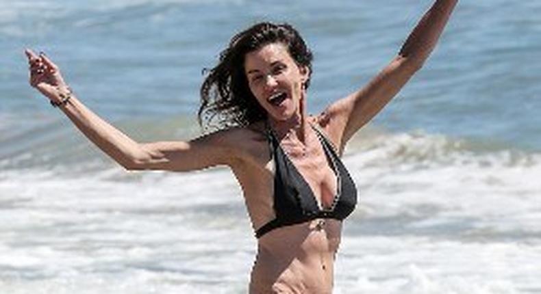 Janice Dickinson rocking a black halter neck bikini, while frolicking at a Malibu Beach