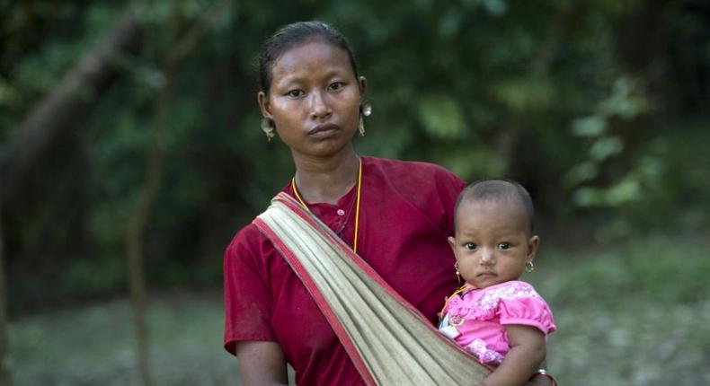 A displaced woman carries her child at a Buddhist monastery in Rakhine state near the Bangladesh border