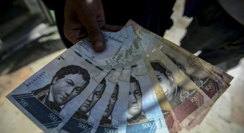 A man shows new 500-Bolivar-notes (74 cents of US dollar) in Caracas on January 16, 2017