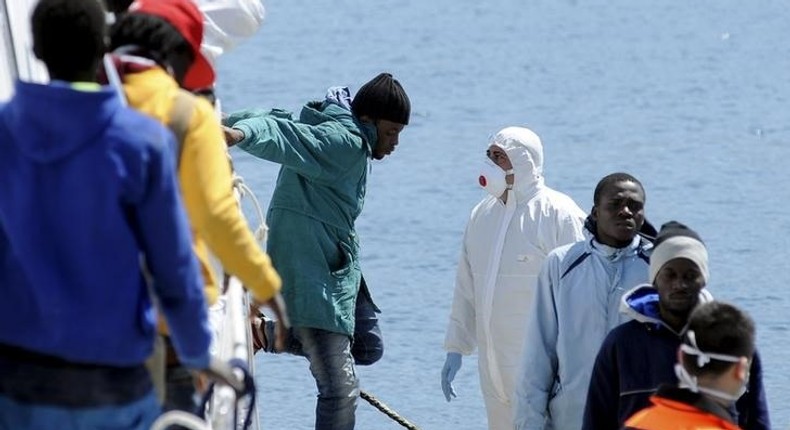 Migrants disembark from a Coast Guard boat as they arrive in the Sicilian harbour of Palermo, April 15, 2015.   REUTERS/Guglielmo Mangiapane