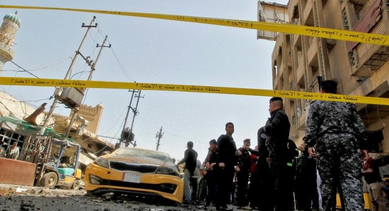 Iraqis gather at the site of a car bombing near Baghdad's Al-Shuhada Bridge on May 30, 2017 which killed at least 11 people