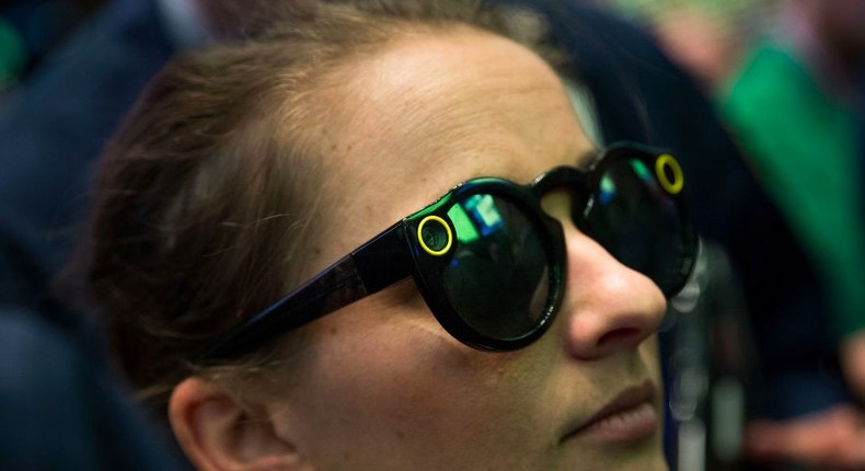 A woman wears 'Snapchat Spectacles' on the floor of the New York Stock Exchange (NYSE), March 2, 2017 in New York City. Snap Inc. shares opened at 24 dollars per share on the NYSE.