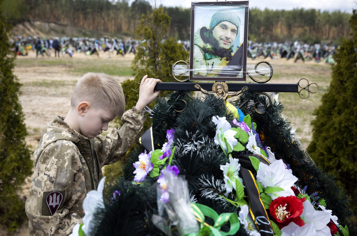 10-letni Sawielij na grobie swego ojca, który zginął broniąc Irpienia w szeregach ukraińskiej samoobrony. Cmentarz w Irpieniu, 1 maja 2022 r. 