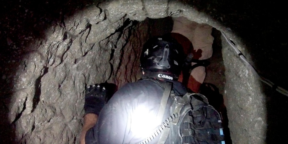 A Homeland Security agent enters a tunnel used to smuggle drugs between the US and Mexico in this photo released on October 31, 2013, by the US Immigration and Customs Enforcement Department (ICE). The tunnel linked an industrial park in Otay Mesa, California, with Tijuana, Mexico, and featured both rail and ventilation systems.