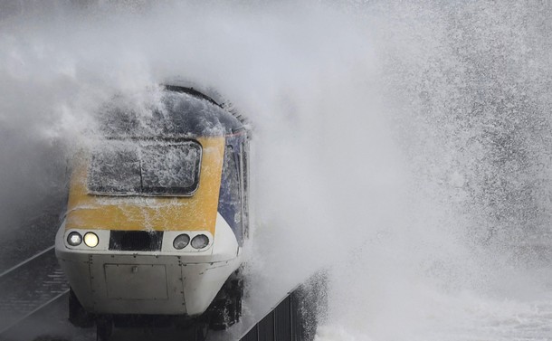 Waves hit a train during heavy seas and high winds in Dawlish in south west Britain