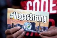 A man holds a sign during a prayer vigil in honor of those affected by the shooting in Las Vegas