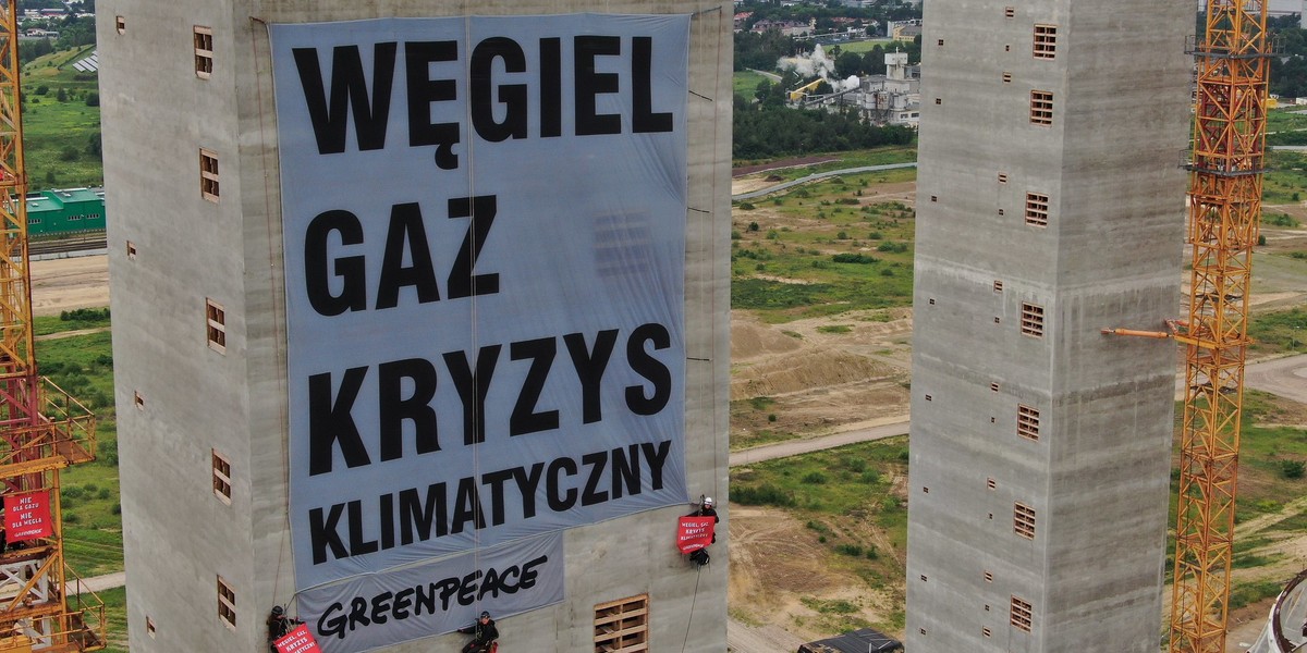 Aktywiści Greenpeace wieszają baner z hasłem "Węgiel, gaz, kryzys klimatyczny" na ponad stumetrowej betonowej wieży na placu budowy elektrowni Ostrołęka C. 23.06.2020 r.