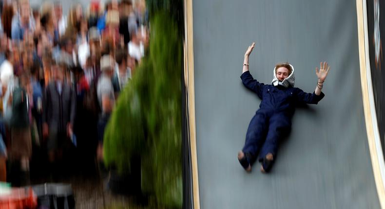 A reveller drops down a slide during the Glastonbury Festival at Worthy Farm in Somerset, Britain June 23, 2016.