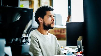 Man adding footnotes to presentation on office computer