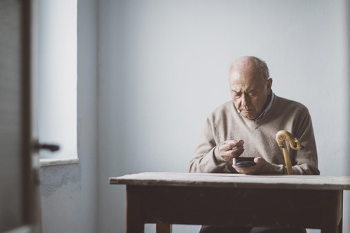 An elderly man look for some money from his wallet