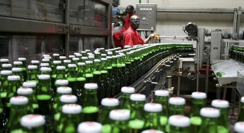 Technicians inspect beer bottles on a conveyor belt at a brewery in Gisneyi, western Rwanda, in a file photo. REUTERS/Hereward Holland