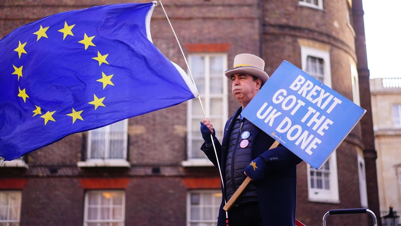 Uczestnik anty-brexitowej demonstracji w Londynie trzymający flagę UE i transparent z hasłem: "Brexit zniszczył Wielką Brytanię"