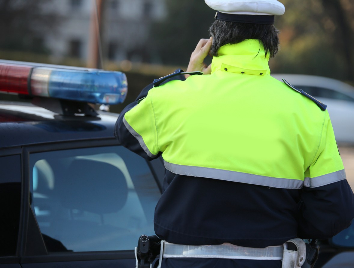 Policajt počas cestnej kontroly preveruje kompletnosť povinnej výbavy v batožinovom priestore.&nbsp; 