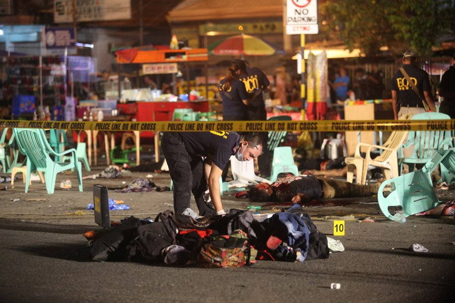 Bodies lie on the ground while police investigators inspect the area of a market where an explosion happened in Davao City, Philippines, September 3, 2016.