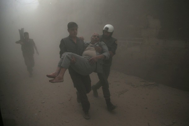 Civil defense members carry an injured man after an air strike in the rebel-held Douma neighbourhood