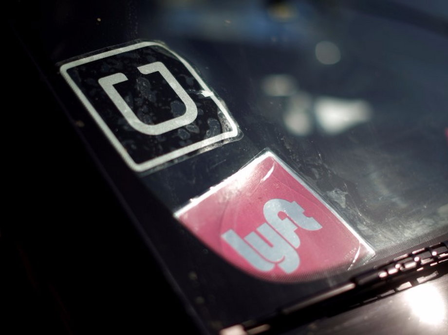 A driver displaying Uber and Lyft signs on his car in Santa Monica, California.