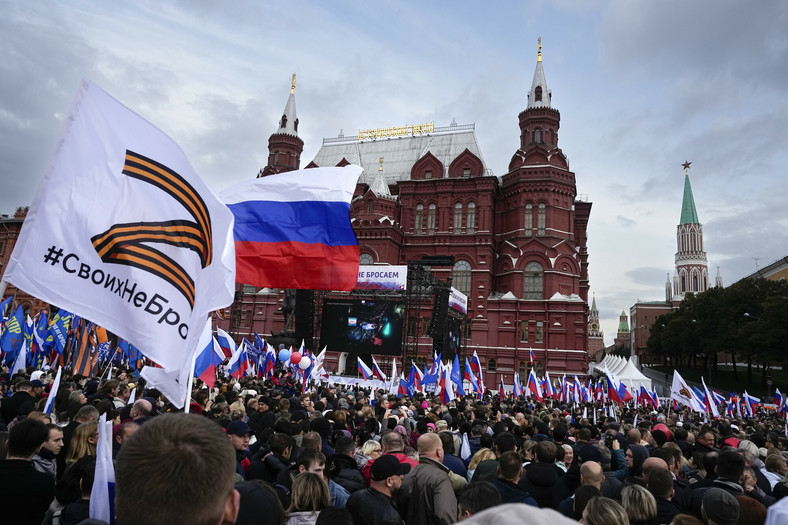 Demonstranci trzymający rosyjskie flagi państwowe i flagi z literą Z, symbolem rosyjskiej inwazji