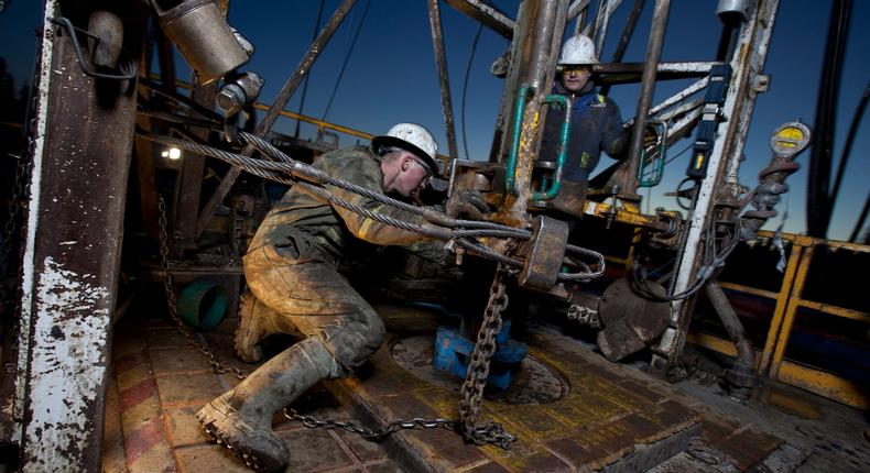 Canada, Alberta, Oil workers using oil drill.