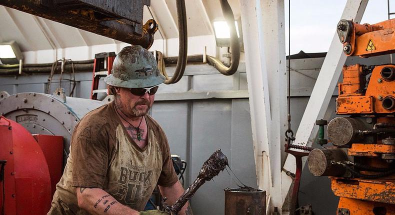 Glen Crabtree, a floor hand for Raven Drilling, lubricates a pipe while drilling for oil in the Bakken shale formation on July 23, 2013 outside Watford City, North Dakota