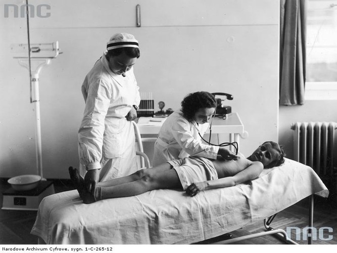 Przedwojenny polski szpital. Pani doktor i pielęgniarka zajmują się pacjentem