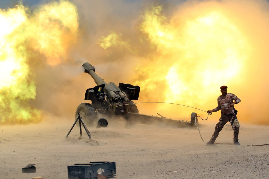 A member of the Iraqi security forces fires artillery during clashes with ISIS militants near Fallujah, Iraq.