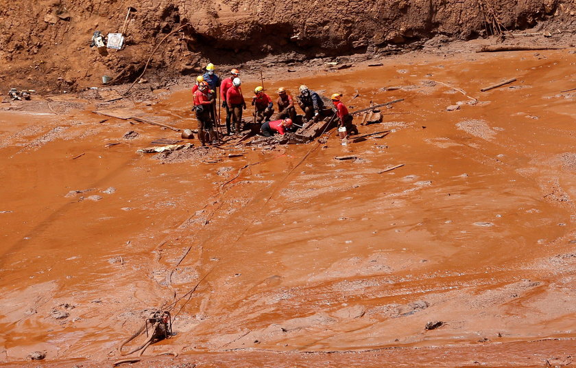 Members of a rescue team carry a body recovered after a tailings dam owned by Brazilian mining compa