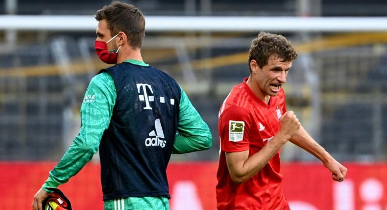 Bayern Munich's Thomas Mueller elbow bumps substitute goalkeeper Sven Ulreich after the Borussia Dortmund win