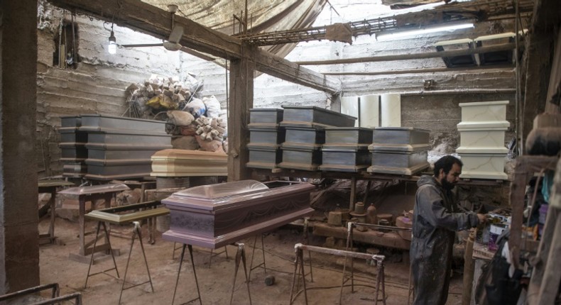 A worker prepares to paint a coffin at a factory in Lima's  Juan de Lurigancho district